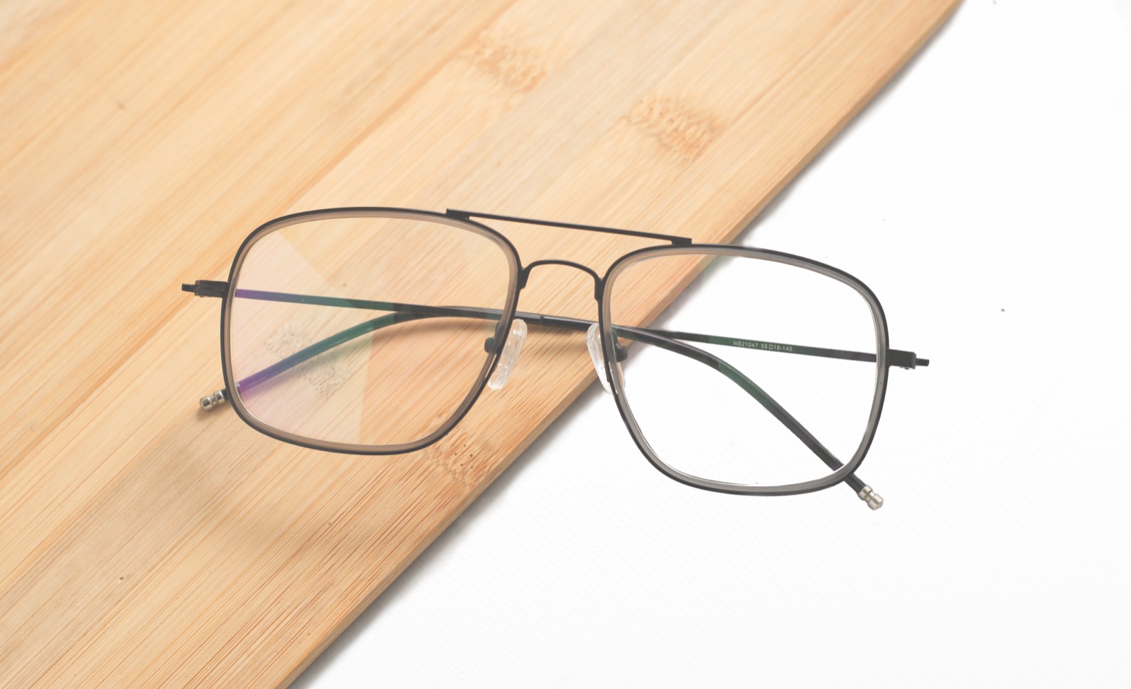 Gafas de montura metálica sobre tabla de madera de bambú