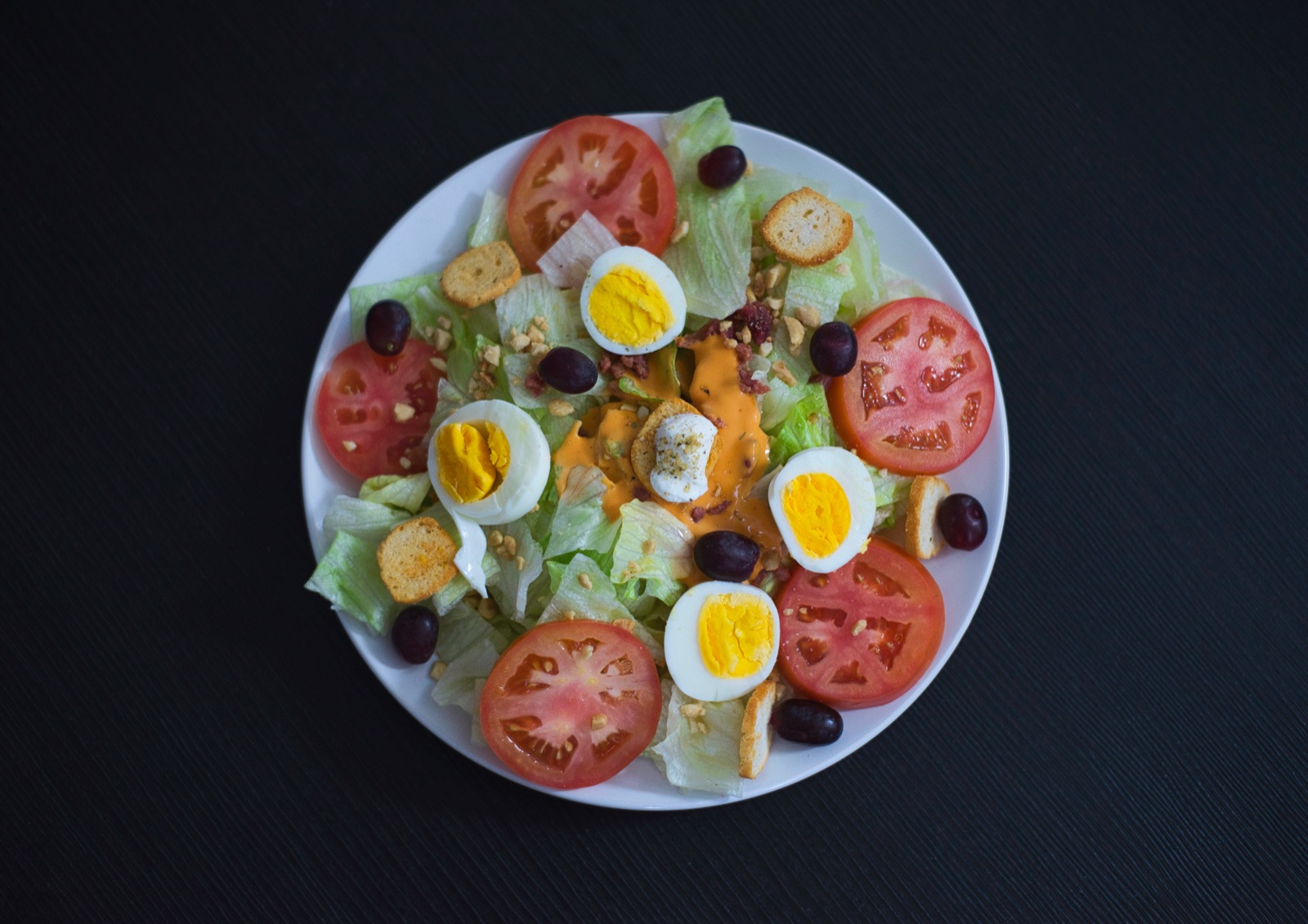 Ensalada con tomate, huevo y aceitunas vista desde arriba