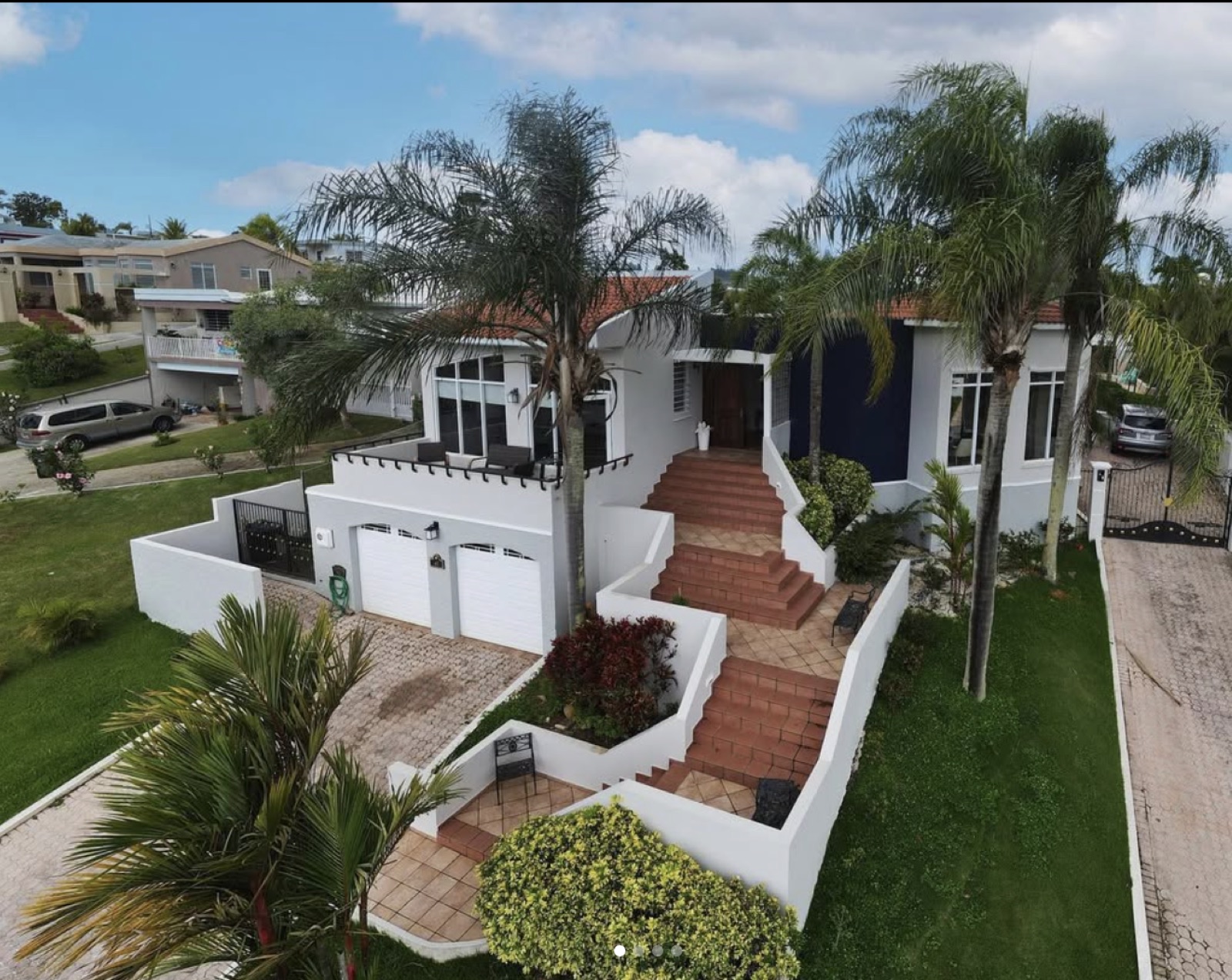 Vista aérea de residencia de lujo con palmeras y techo de teja