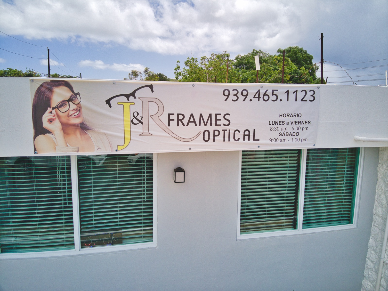 Fachada de óptica J&R Frames con banner exterior